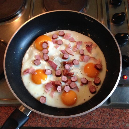 Fried eggs with smoked ham and Polish sausages
