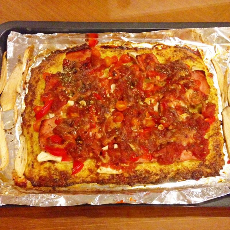 cauliflower pizza with mushrooms, rosemary ham, tomatoes, red peppers, mozzarella, homemade pizza sauce