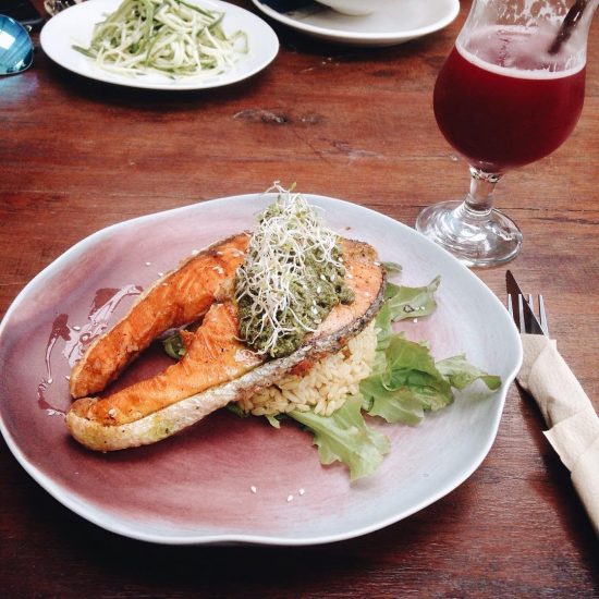 Salmon with presto sauce and brown rice served with beetroot , cucumber, ginger cold press juice